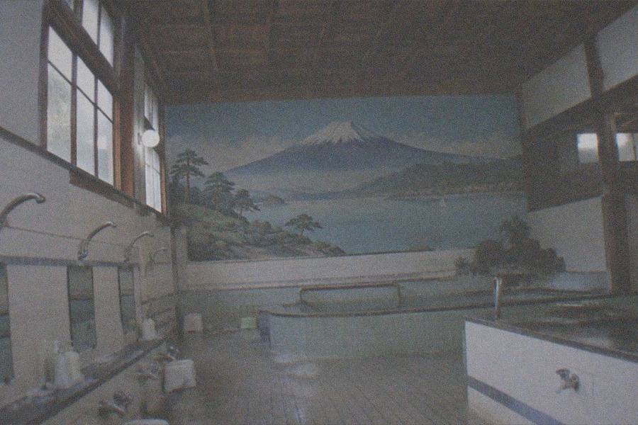 A relocated historic Japanese building with tiled roof standing among trees at the Edo-Tokyo Open Air Architectural Museum