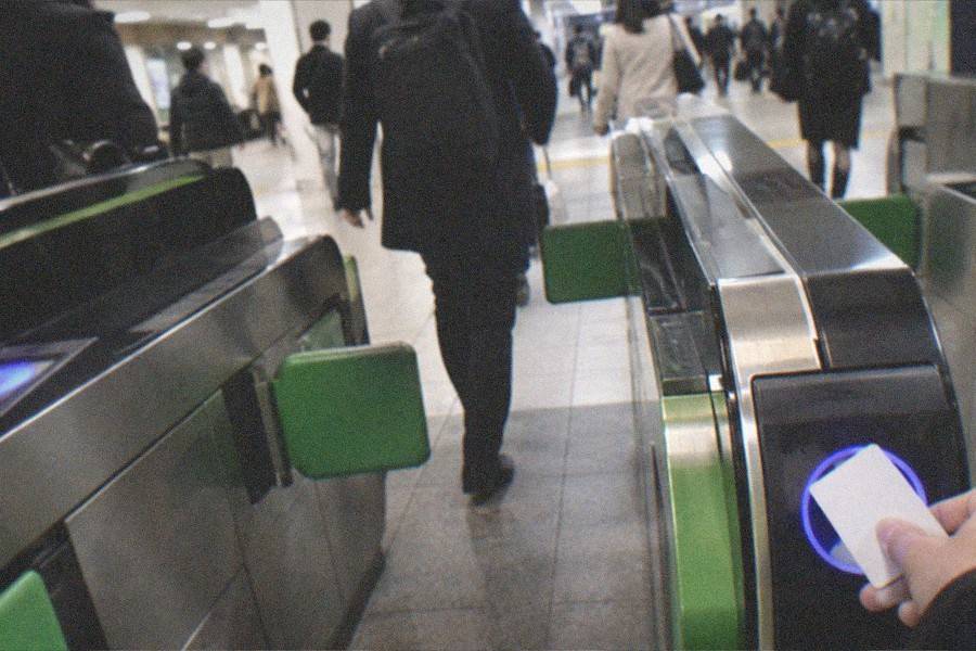 A ticket machine and queue barriers inside a Tokyo station concourse
