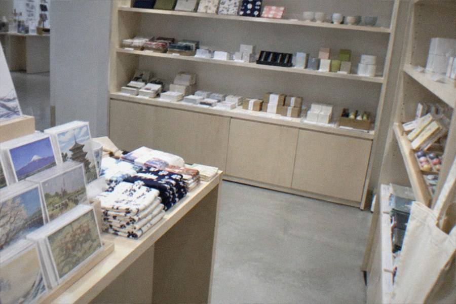 A museum gift shop entrance with postcards and books displayed near the exit