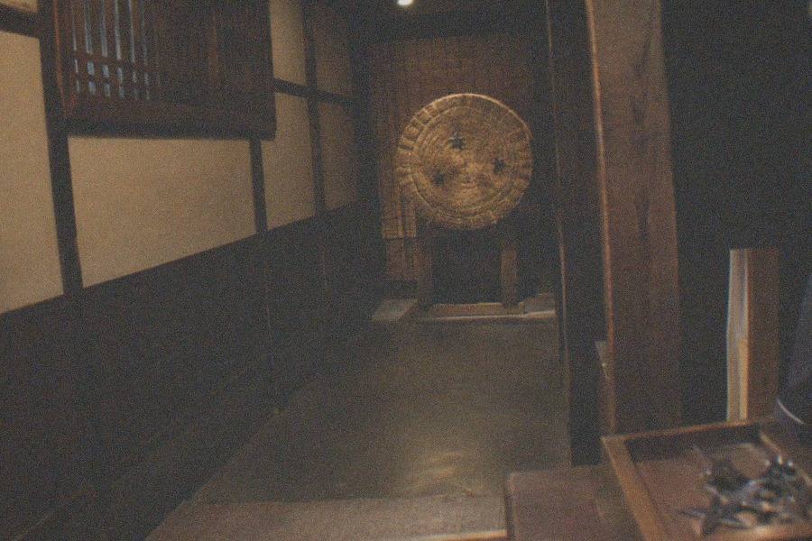 A visitor dressed in full samurai armour holding a katana inside Samurai Ninja Museum Tokyo