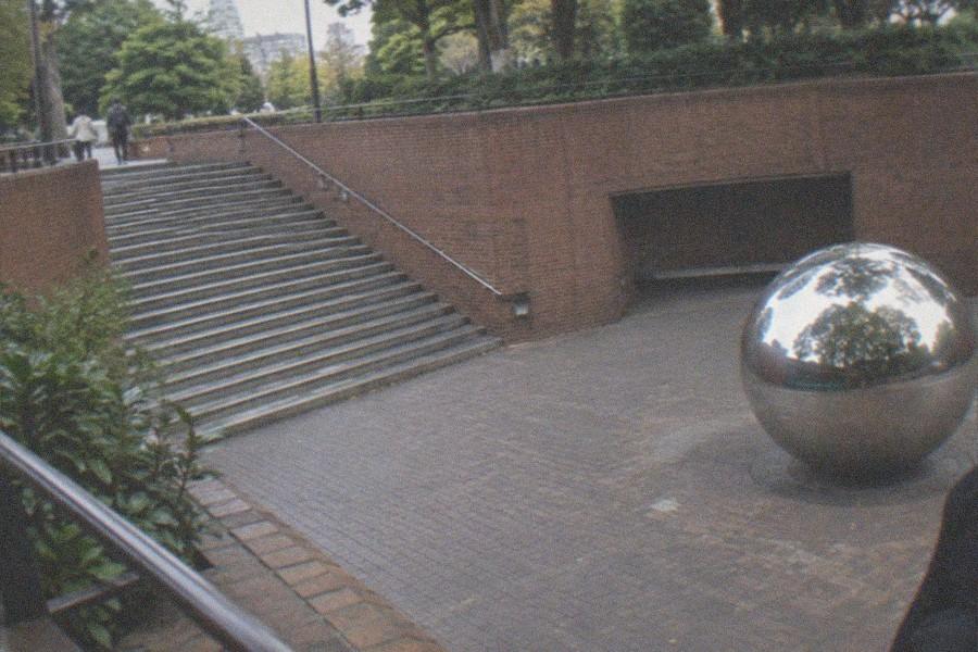 Visitors walking through the stone and glass entrance forecourt of the Tokyo Metropolitan Art Museum in Ueno Park